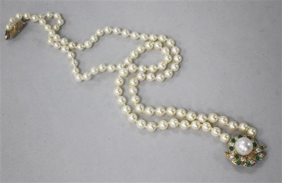 A single strand graduated cultured pearl necklace with 9ct gold diamond and emerald set pendant, 44cm.